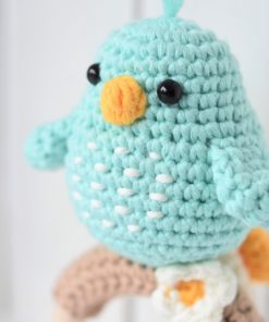 amigurumi bird on a wooden teething ring