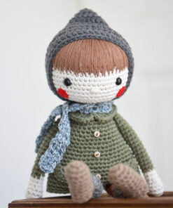 amigurumi doll in a coat and bonnet